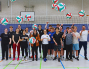 Gruppenfoto des Sportkurses, zwei Spielerinnen der Ladies in Black und Verantwortlichen für die Schulkooperation