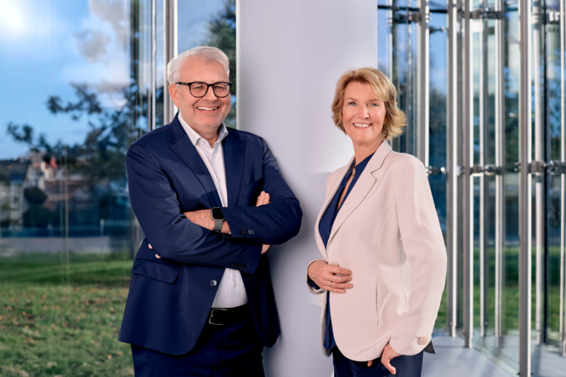 Bild im Kundenzentrum der STAWAG von Vorstand: Links Wilfried Ullrich mit Brille und in Anzug an Säule lehnend, rechts Alexandra Genten in Hosenanzug an Säule lehnend.